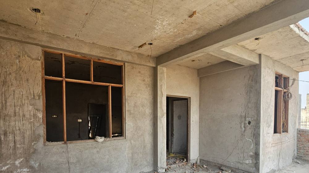 Interior of the house after plaster, showing beams, the slab soffit, framed openings and plastered walls.