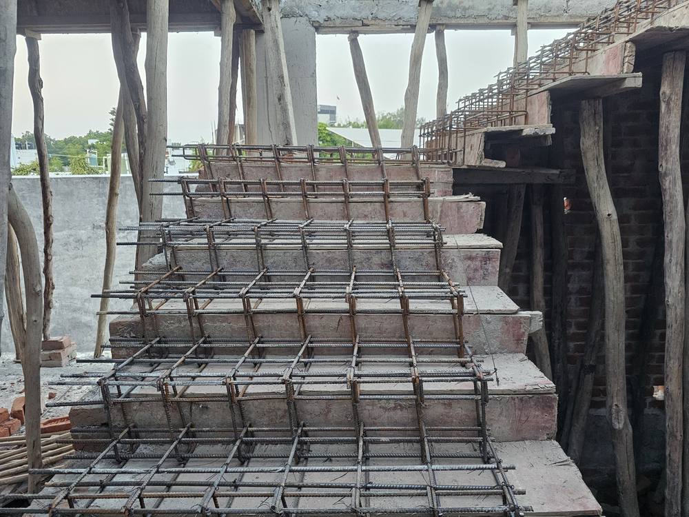 Staircase reinforcement tied over shuttered treads and risers, with timber props below.